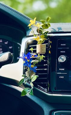 a car dashboard with a radio and flowers in the air vent on top of it