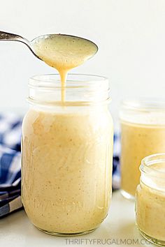 a spoon is being used to dip something in a jar