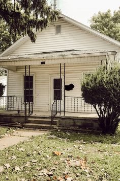 an old white house sitting on the side of a road