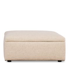 a beige ottoman with black legs on a white background