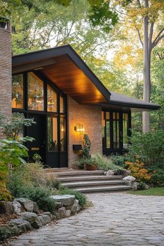 a modern house in the woods with steps leading up to it's front door