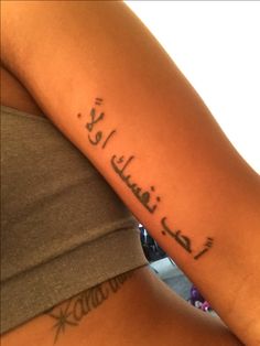 a woman with a tattoo on her arm that reads, i love you in arabic