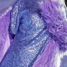 a close up of a purple and blue dress with sequins on the sleeves