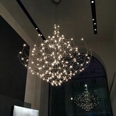 a large chandelier hanging from the ceiling in a room with lights on it