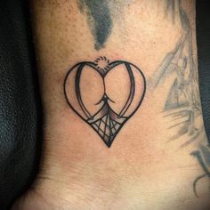 a tattoo on the foot of a person with a heart and two arrows in it