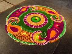 a colorfully decorated table with candles on it in the shape of a flower and leaves