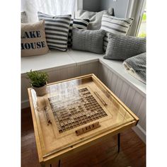 a coffee table with a game on it sitting in front of a window next to pillows