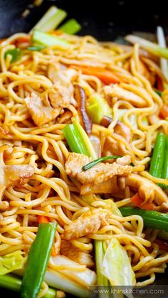 stir fried noodles with chicken and vegetables in a wok