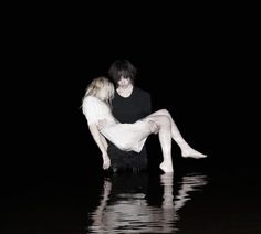 two people are sitting in the water with their feet on each other's legs