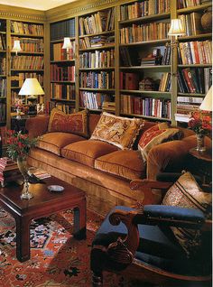 a living room filled with lots of furniture and bookshelves full of books on shelves