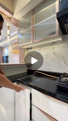 a woman standing in front of a stove top oven next to a white countertop