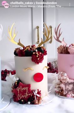 two cakes decorated with reindeer heads and flowers on top of a table next to each other