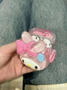 a person holding a hello kitty cell phone case in their left hand and wearing a pink bow