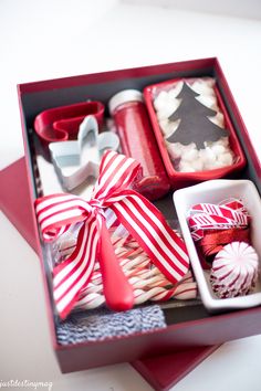 an open box filled with different types of cookies and candies on top of a table