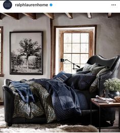 an image of a bedroom setting with blue and green comforter on the bed in front of two windows