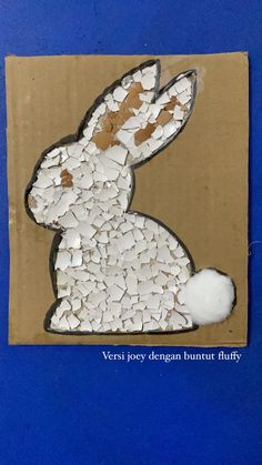 a cardboard box with a white rabbit cut out of it's side on a blue background