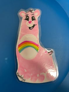 a pink plastic animal with a rainbow on it