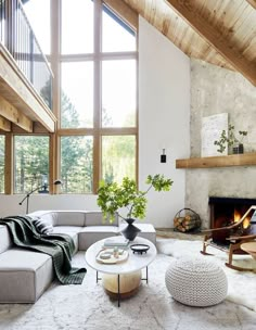 a living room filled with furniture and a fire place in front of a large window