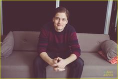 a young man sitting on top of a couch