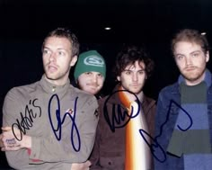 three men standing next to each other with autographs on them