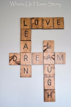 a cross made out of scrabble tiles with the words love and dream spelled on it