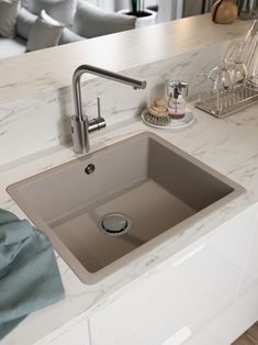 a kitchen sink sitting under a faucet on top of a counter