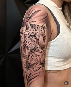 a woman's arm with a leopard and flowers tattoo on it