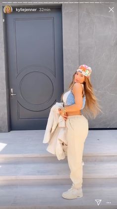 a woman is standing on the steps with her legs crossed and wearing a bandana over her head