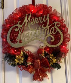 a red christmas wreath hanging on the front door