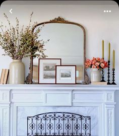 a fireplace with flowers and pictures on it