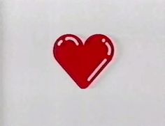 a red heart shaped sticker sitting on top of a white surface