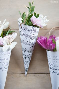 three flower vases with music notes and flowers in them