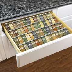 an open drawer in a kitchen filled with spices