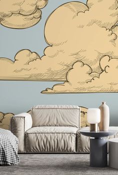 a living room with a couch, table and clouds painted on the wall behind it