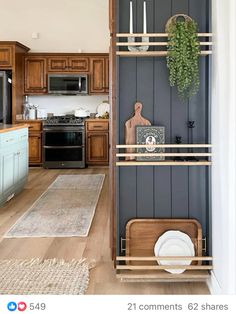 a kitchen with blue cabinets and wooden shelves in the center is decorated with greenery