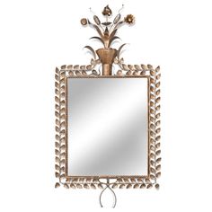 a mirror that is on the wall with some flowers in front of it and an iron frame