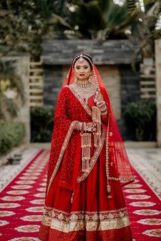 a woman in a red and gold wedding outfit