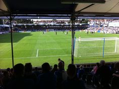 a group of people watching a soccer game on a large field with lots of spectators