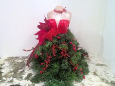 a mannequin is adorned with red bows and poinsettis