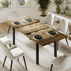 a dining room table with four chairs and plates on the top, in front of a window