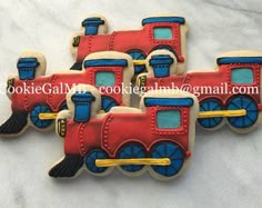 four decorated cookies in the shape of trains