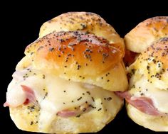 two ham and cheese sliders on a black background