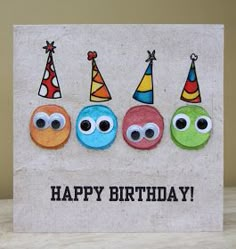 three donuts with eyes and party hats on them are in the middle of a happy birthday card