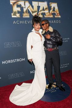 two people posing on the red carpet at an event