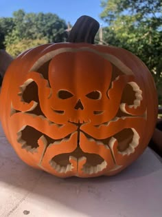 a carved pumpkin with an image of a skull on it's face in the center