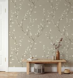 a room with a table, vase and wallpaper on the wall next to it