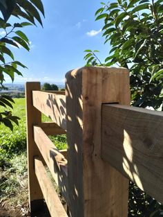 a wooden fence in front of some trees