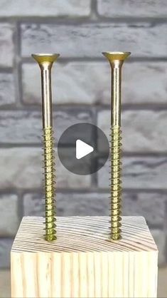 two screws are placed on top of a piece of wood, with the video below it