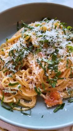 pasta with tomatoes and parmesan cheese in a blue bowl