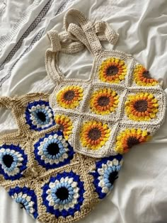 two crocheted bags sitting on top of a bed